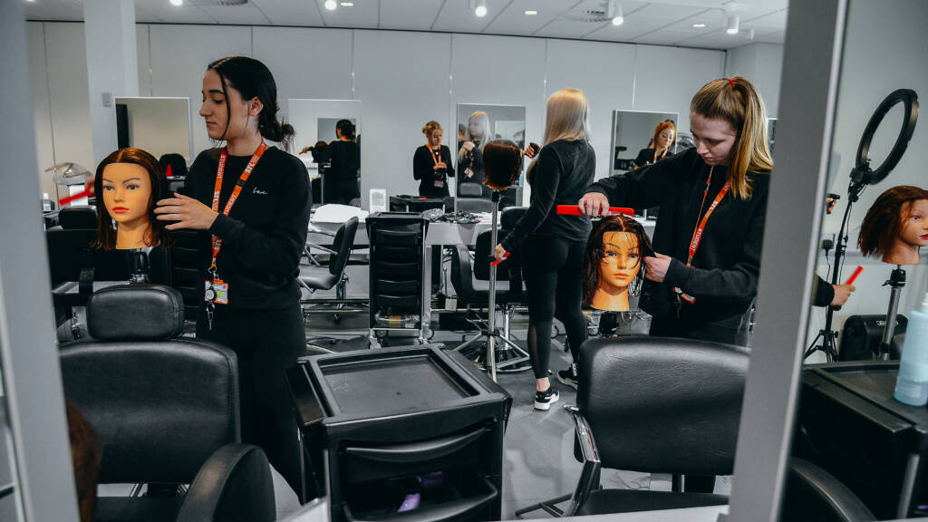 SRC hairdressing students are styling hair on training heads in the SRC hair salon