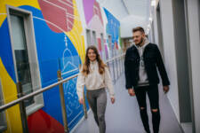 Two SRC students walking down brightly decorated corridor in SRC campus