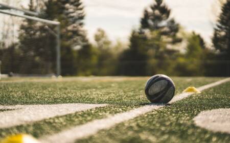 Close up of football on a football pitch with football net in the background