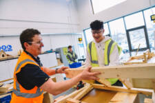 SRC students wearing hi-vis jackets working with wood in college workshop.