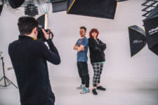 Two students are posing while another student takes their photography within the SRC Photography studio