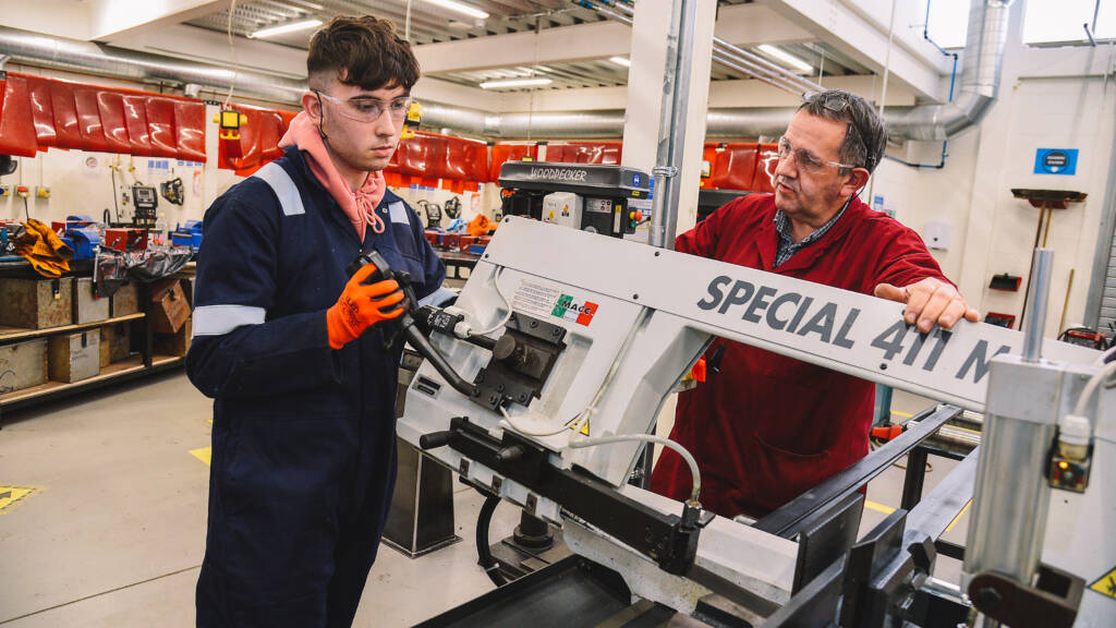 Student and staff member working with equipment in motor vehicle workshop