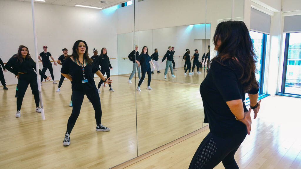 Group of SRC students in a large mirrored dance studio in SRC Armagh campus, taking part in a dance class.