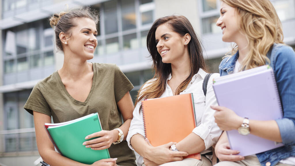 Smiling students chatting with books outside unive 2026 09 21 10 19 10 utc