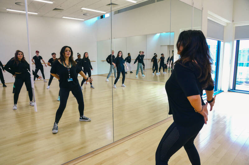 Group of SRC students in a large mirrored dance studio in SRC Armagh campus, taking part in a dance class.