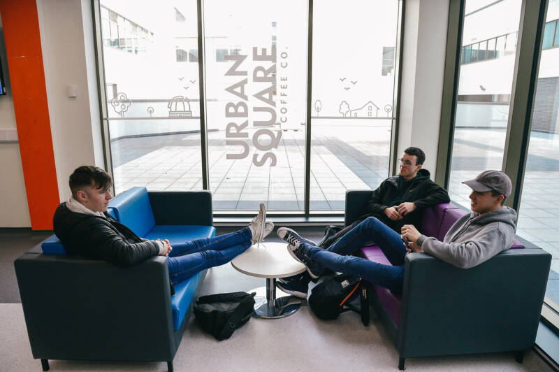 Group of three students seated in cafe area of Armagh Campus