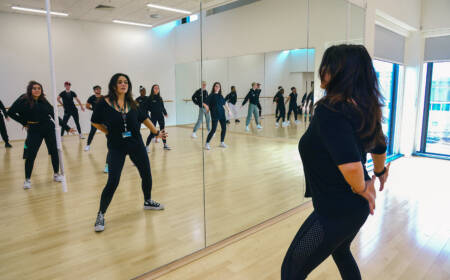 Group of SRC students in a large mirrored dance studio in SRC Armagh campus, taking part in a dance class.