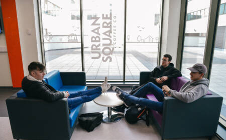 Group of three students seated in cafe area of Armagh Campus